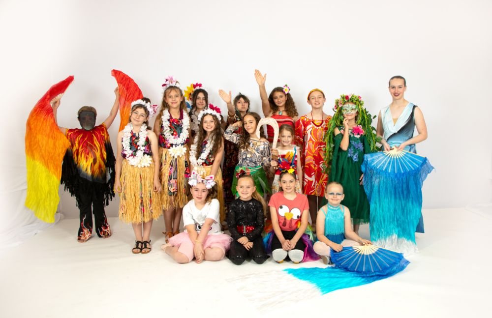 The full cast of a studio musical in costume on stage